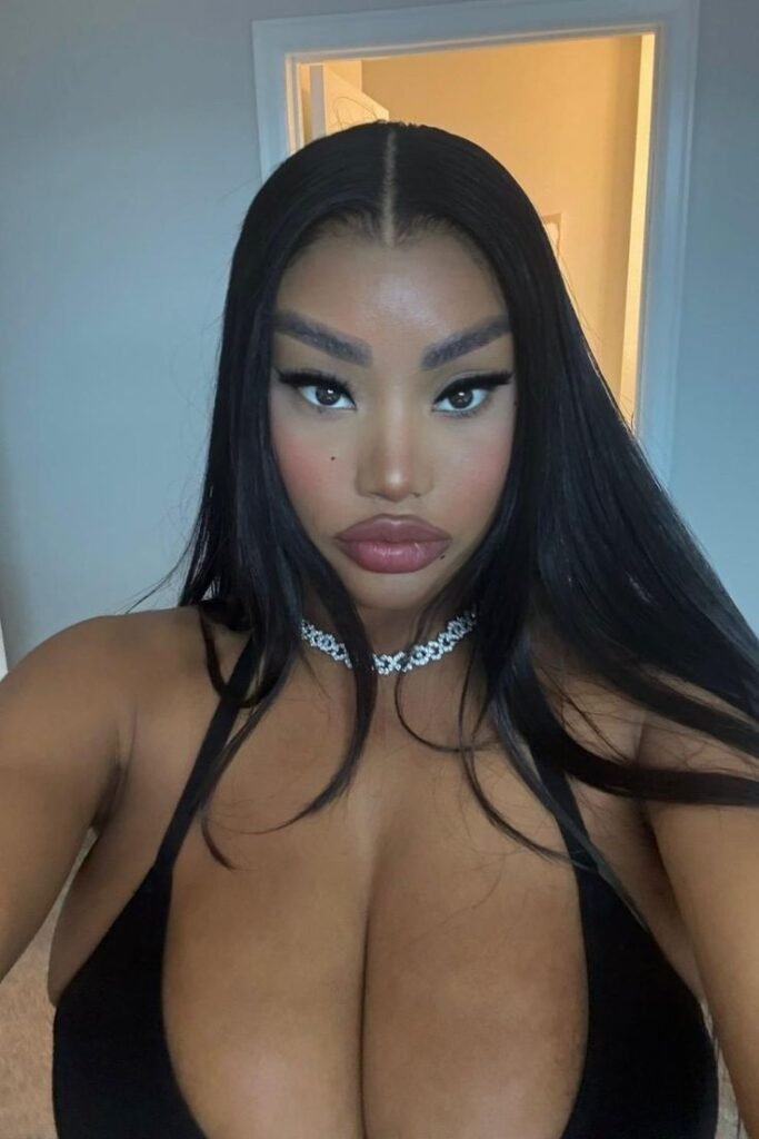 Bold glam UK phone chat model Nyara Velloux with sleek hair and intense confident gaze