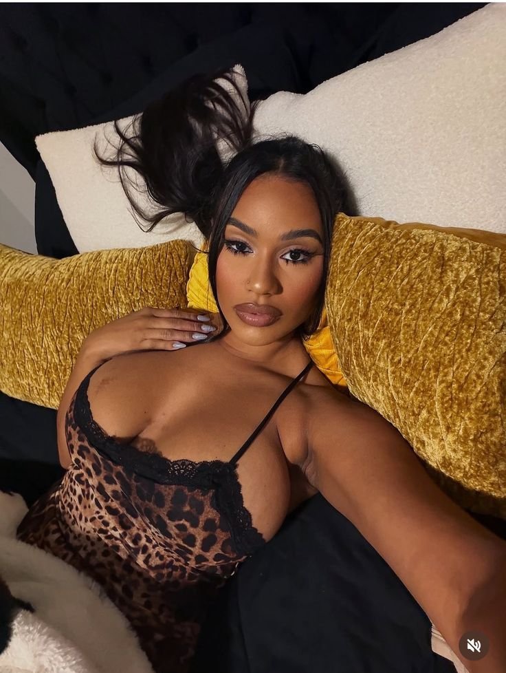 Intimate curvy UK phone chat model Zalina Noire reclining in leopard print with confident gaze