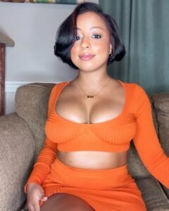 Elegant curvy woman seated indoors representing phone sex chat UK and adult chat with horny girls