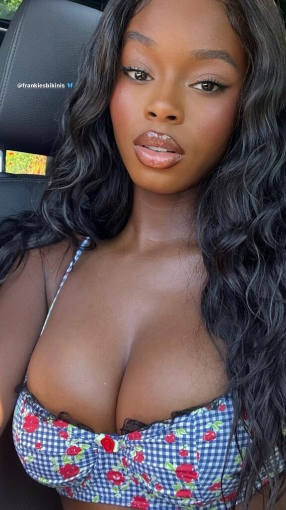 Soft-glam curvy UK phone chat model Améline Rowe with glossy lips and calm confident car-selfie presence