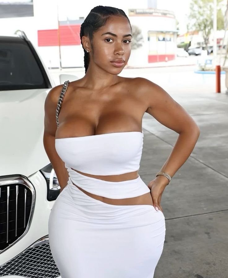 Refined curvy UK phone chat model Elowyn Harté in a white outfit with confident composed presence