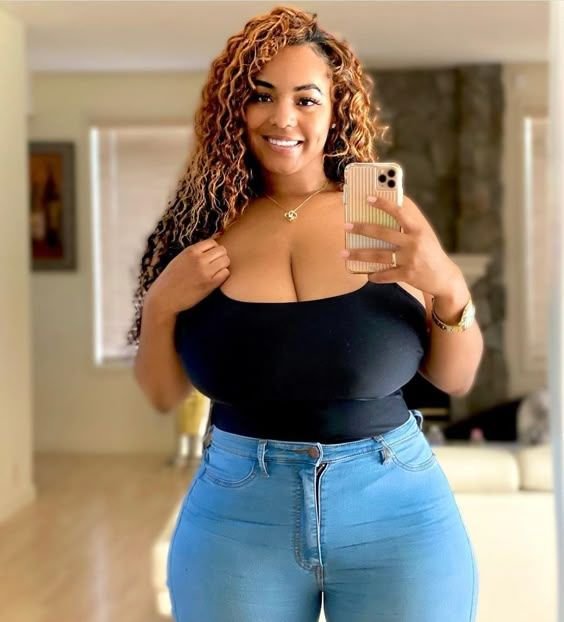 Confident curvy woman taking a mirror selfie representing phone sex chat UK and adult chat with horny girls