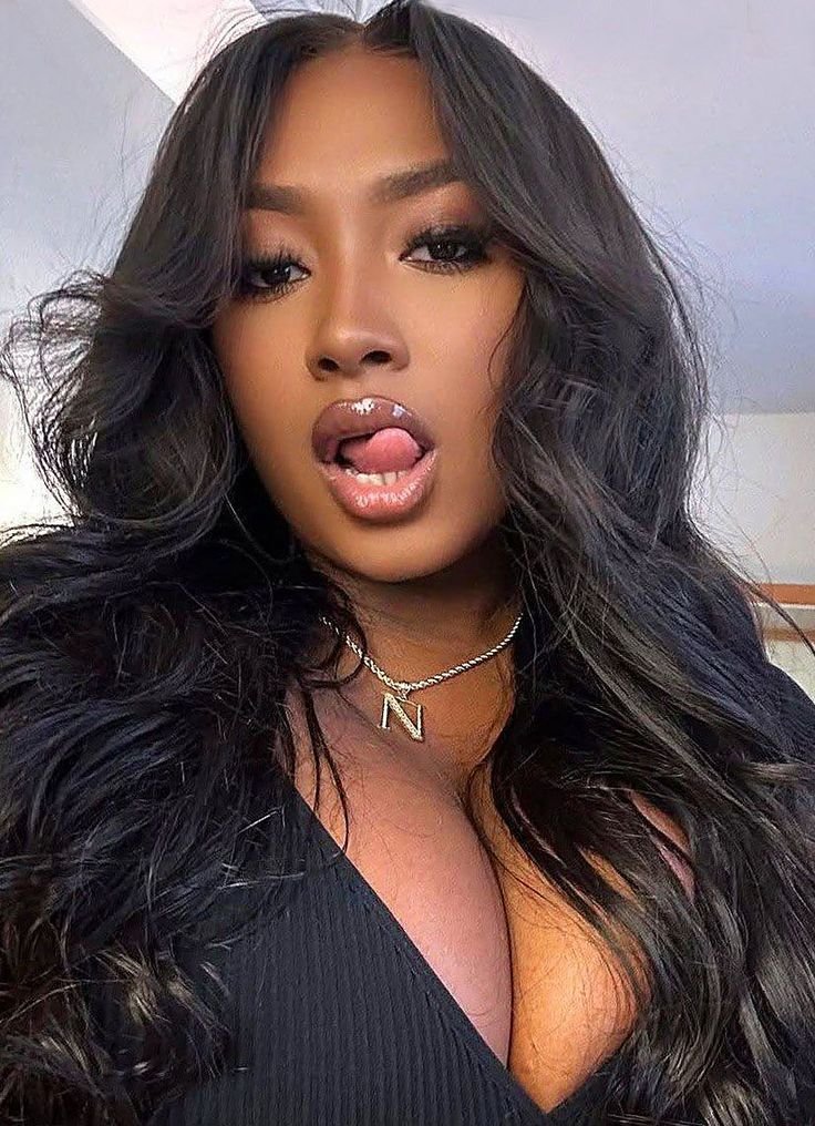 Bold glam UK phone chat model Neriah Vanté with voluminous waves and playful confident expression