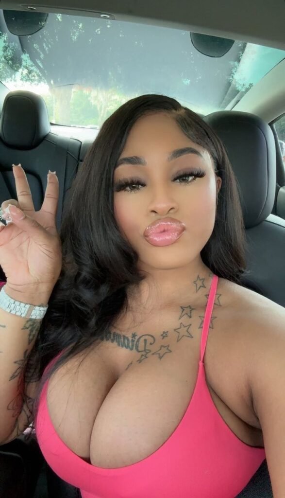 Playful curvy UK phone chat model Lunara Skye taking a car selfie with a peace sign and confident flirty expression