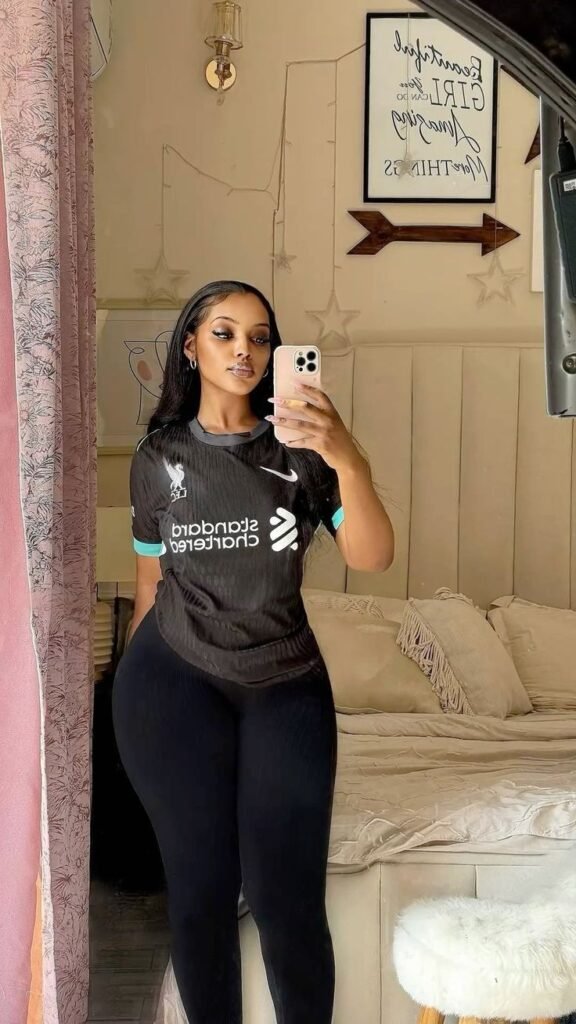 Sporty confident woman taking a mirror selfie representing phone sex chat UK and adult chat with horny girlsA confident woman taking a mirror selfie indoors wearing a sporty fitted top and leggings. The image represents adult chat UK, phone sex chat uk, uk adult chat, and relaxed live phone sex chat experiences.