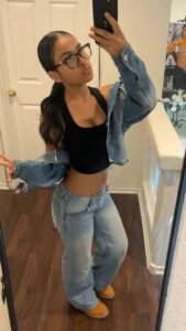 Confident young woman taking a mirror selfie representing phone sex chat UK and adult chat with horny girls