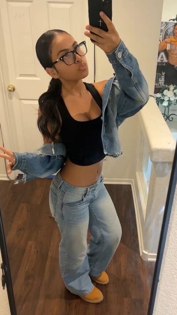 Confident young woman taking a mirror selfie representing phone sex chat UK and adult chat with horny girls