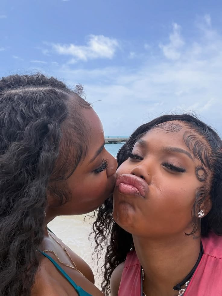 Girls on girls chat UK profile featuring two women at the beach Lesbian phone chat UK female duo with natural curly hair Women seeking women chat profile with playful expressions Girls on girls phone chat UK profile image Lesbian chat lines UK confident female pair