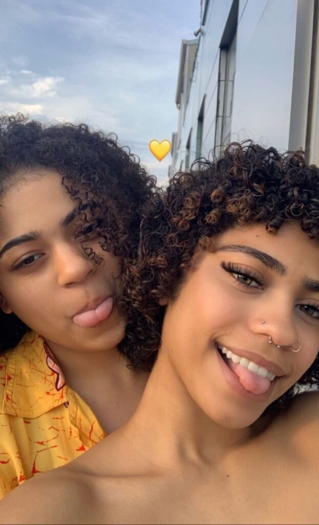 Girls on girls chat UK profile featuring two women with natural curls Lesbian phone chat UK friendly female duo Women seeking women chat profile with casual style Girls on girls phone chat UK profile image Lesbian chat lines UK confident female pair