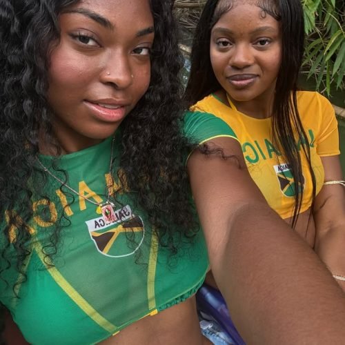 Girls on girls chat UK profile featuring two women in Jamaica-inspired outfits Lesbian phone chat UK female duo with coordinated casual fashion Women seeking women chat profile with tropical style Girls on girls phone chat UK profile image Lesbian chat lines UK confident female pair Adult chat UK girls on girls category profile