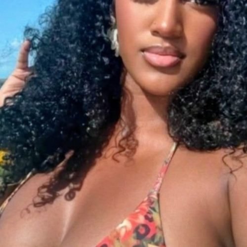 Luxury FemDom companion with long natural curly hair Confident woman in floral bikini top Premium fetish phone chat profile image Elegant dominant female companion portrait Curvy fantasy chat companion profile Glamorous FemDom profile photograph Premium adult chatline companion image Stylish luxury fantasy companion portrait