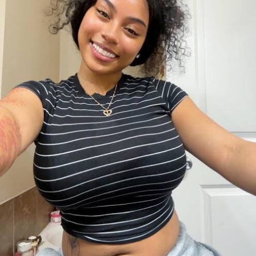 Playful curvy UK phone chat model Caleya Brighton smiling with natural curls and relaxed confident presence
