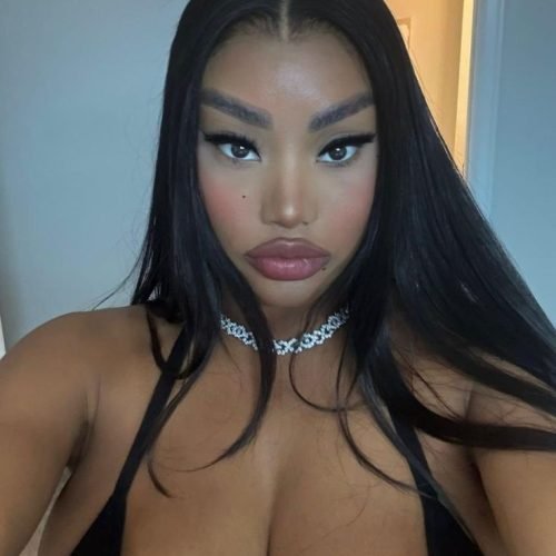 Bold glam UK phone chat model Nyara Velloux with sleek hair and intense confident gaze