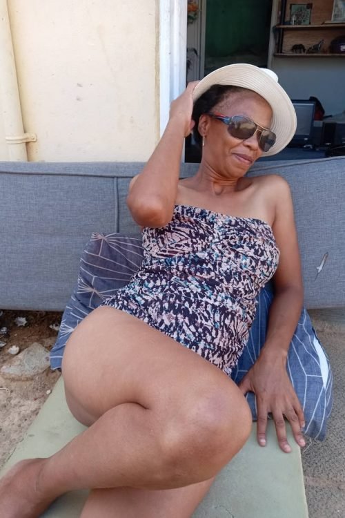 Granny phone sex UK profile featuring mature woman in summer outfit Phone sex grannies UK relaxing outdoors with sun hat Mature granny phone chat profile wearing sunglasses Adult phone chat UK mature woman portrait