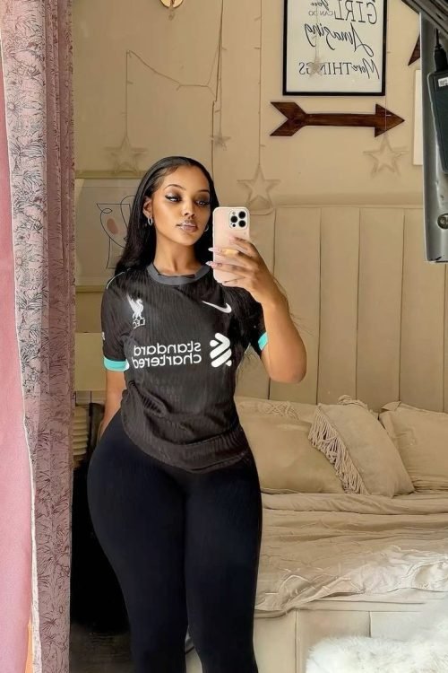 Sporty confident woman taking a mirror selfie representing phone sex chat UK and adult chat with horny girlsA confident woman taking a mirror selfie indoors wearing a sporty fitted top and leggings. The image represents adult chat UK, phone sex chat uk, uk adult chat, and relaxed live phone sex chat experiences.