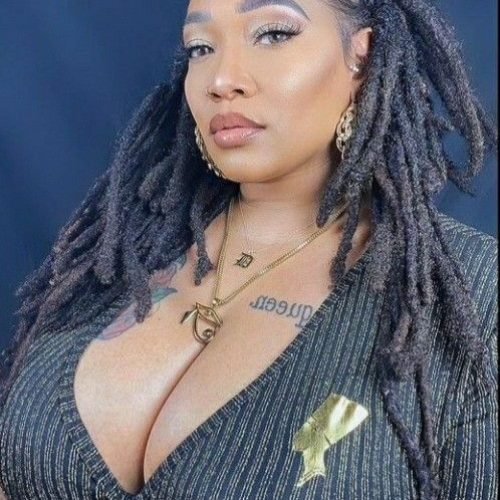 Confident curvy UK phone chat model Zarielle Noire with styled locs and elegant commanding presence