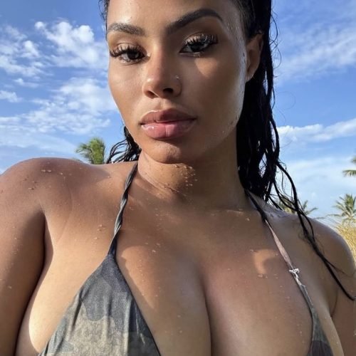 Confident curvy woman wearing a bikini top outdoors with sun-kissed skin and wet hair