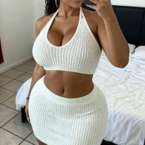 Curvy woman in a white outfit taking a mirror selfie representing phone sex chat UK and adult chat with horny girls