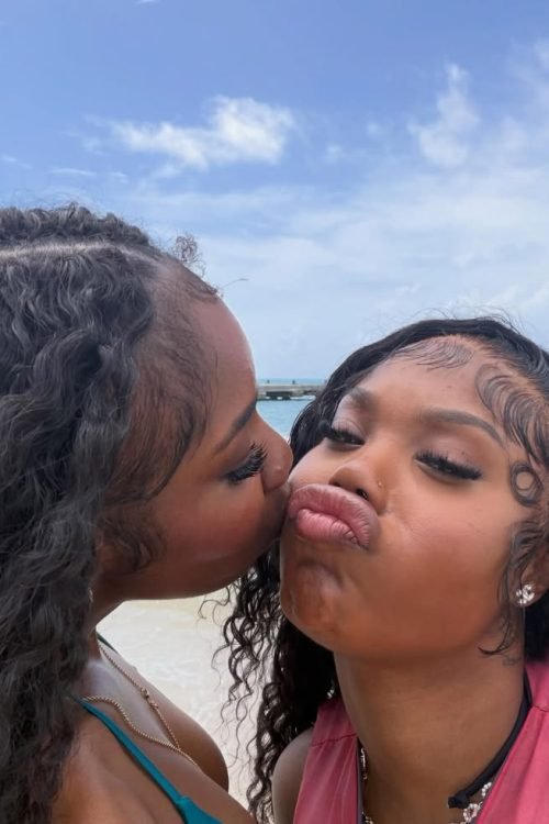 Girls on girls chat UK profile featuring two women at the beach Lesbian phone chat UK female duo with natural curly hair Women seeking women chat profile with playful expressions Girls on girls phone chat UK profile image Lesbian chat lines UK confident female pair