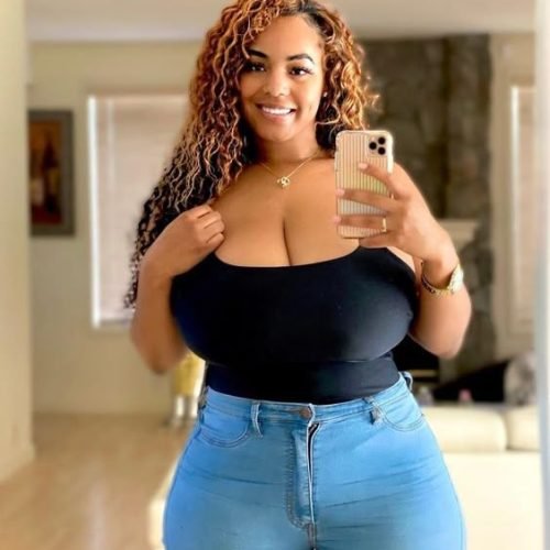 Confident curvy woman taking a mirror selfie representing phone sex chat UK and adult chat with horny girls