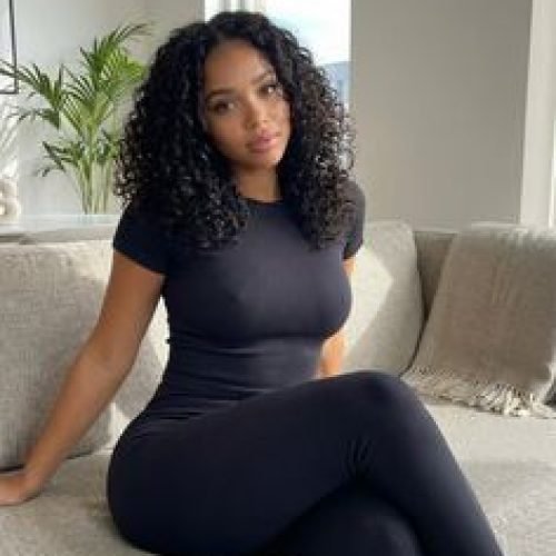 Confident woman sitting on a sofa representing phone sex chat UK and adult chat with horny girls