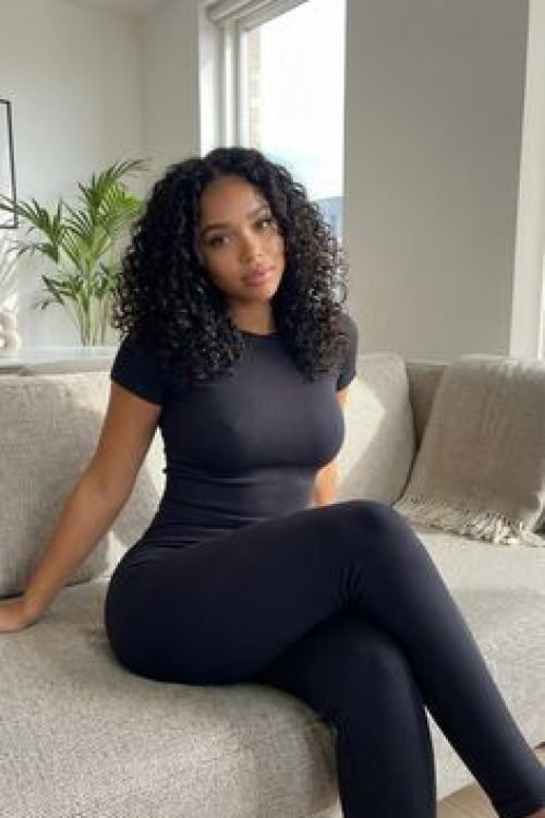 Confident woman sitting on a sofa representing phone sex chat UK and adult chat with horny girls