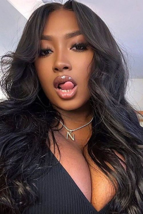 Bold glam UK phone chat model Neriah Vanté with voluminous waves and playful confident expression