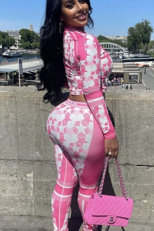 Luxury FemDom companion wearing pink designer-inspired outfit Elegant curvy woman with long black wavy hair Premium fetish phone chat profile image Stylish FemDom companion portrait Confident dominant woman in fashionable pink attire Glamorous curvy fantasy companion profile Luxury adult chatline profile photograph